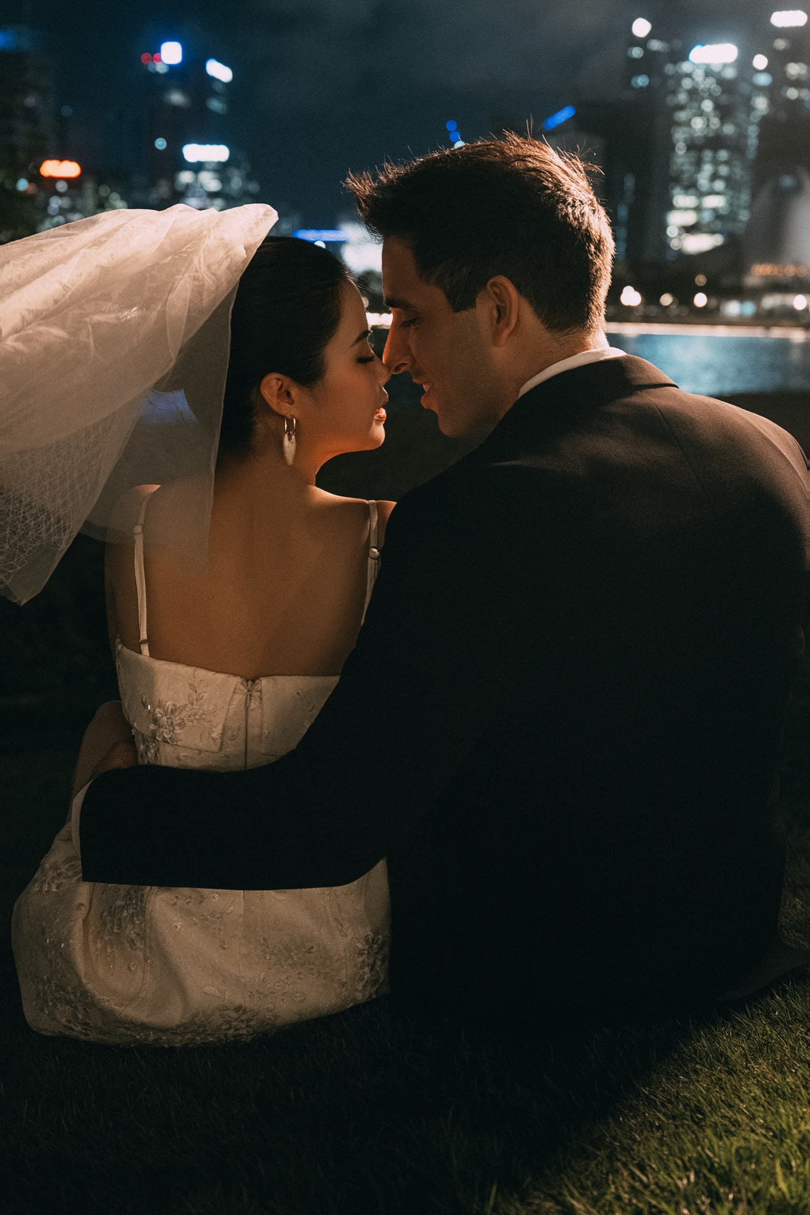 The couple posing together in the studio with a bouquet